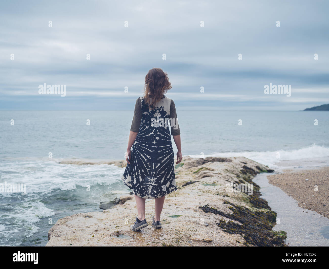 A young woman is standing by the sea Stock Photo - Alamy