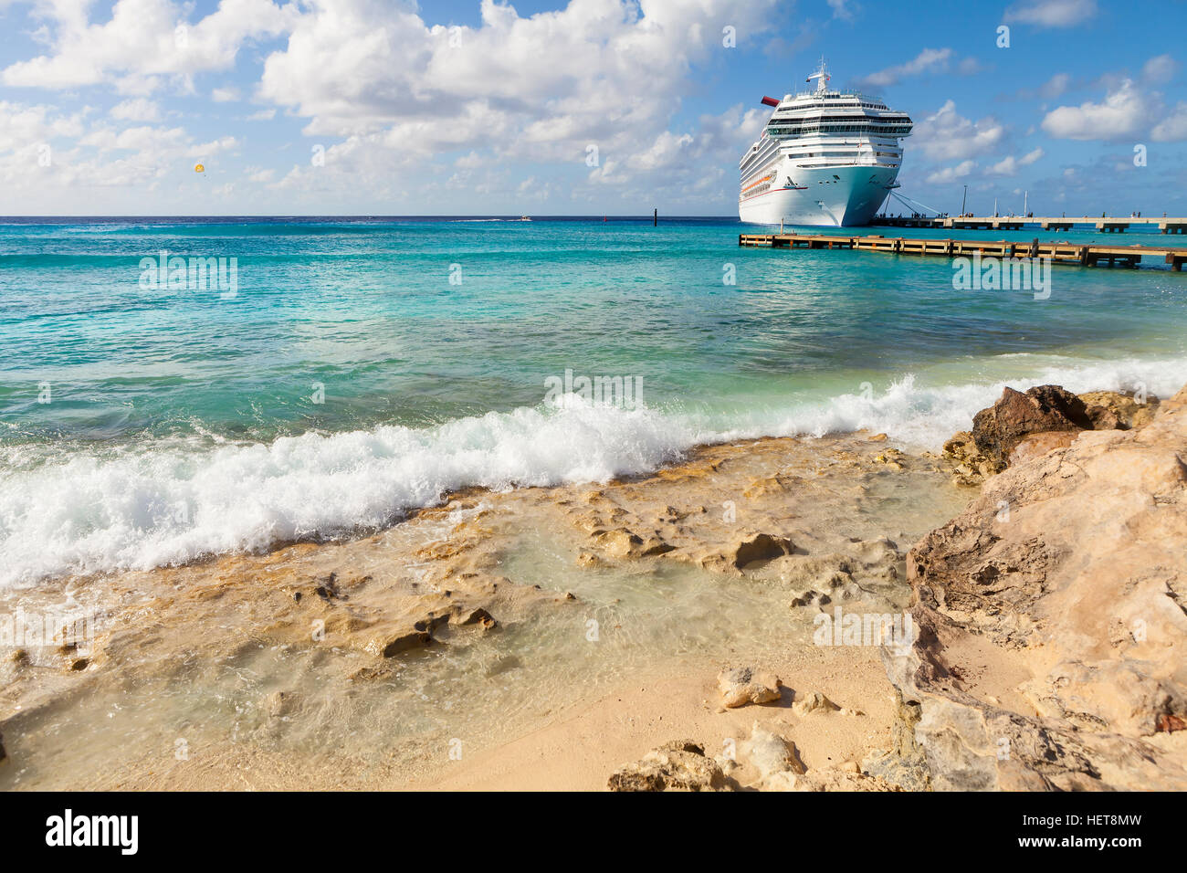 Cruise Ship in Caribbean Tropical Port with ocean surf and shore. Stock Photo