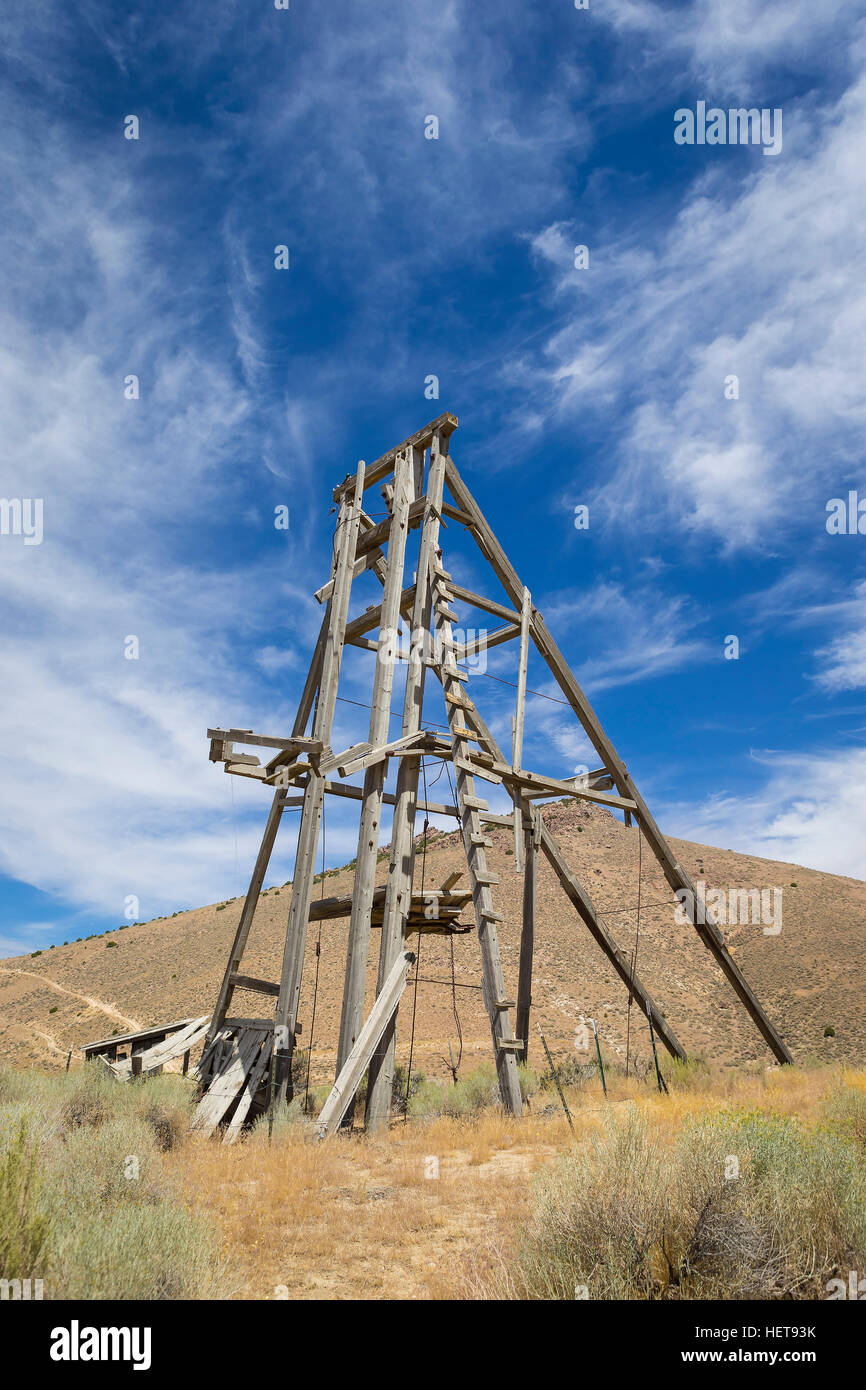 Old mining head frame in the Nevada Desert under blue sky with clouds ...