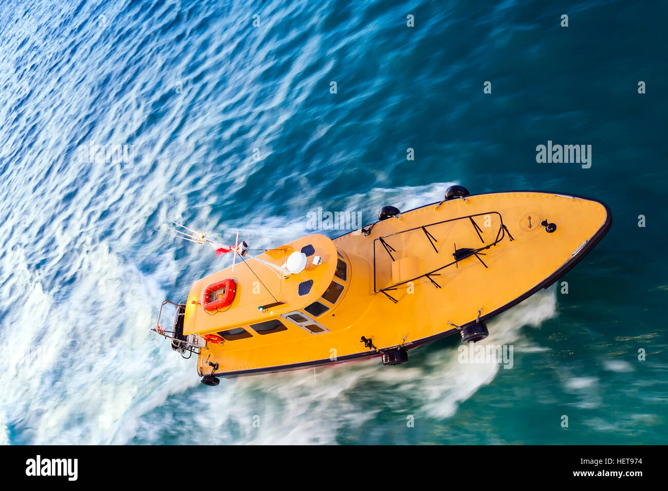 Panning motion blurred shot of speeding Yellow Pilot Boat at Sea Stock Photo