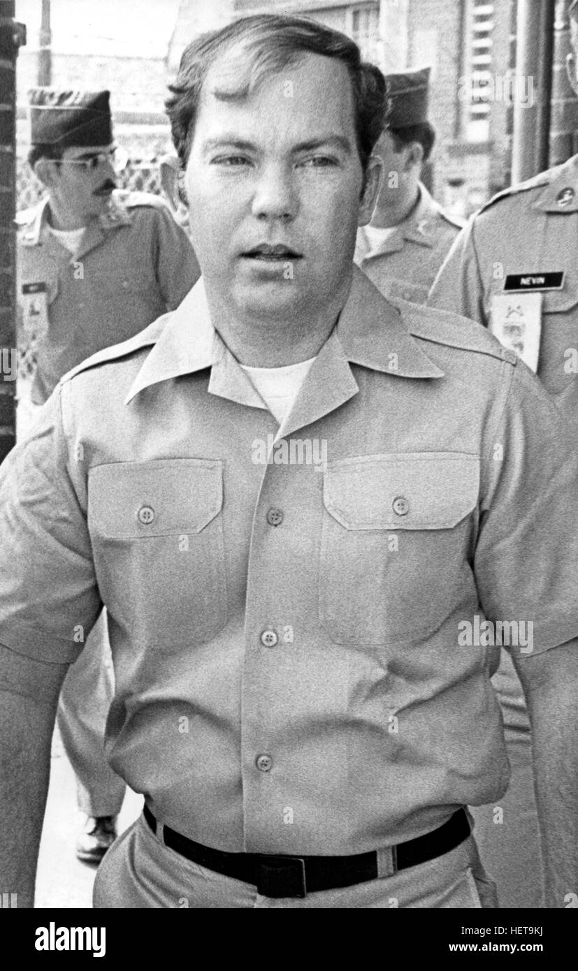 Convicted of the murder of 102 Vietnamese civilians  - the My Lai Massacre -  former U.S. Army Lieutenant William Calley (sunglasses) is escorted from the Fort Benning, Georgia confinement facility to a federal appeals court in nearby Columbus, Ga. At a later date, Calley's original sentence of life in prison was turned into an order of house arrest, but after three years, President Richard Nixon reduced his sentence with a presidential pardon. Stock Photo