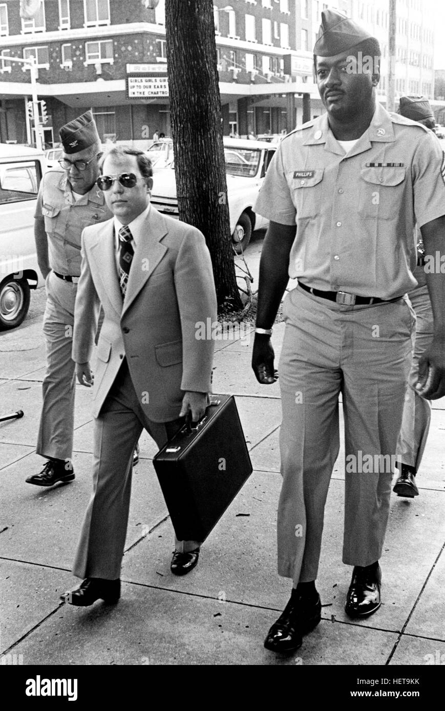 Convicted of the murder of 102 Vietnamese civilians  -the My Lai Massacre - former U.S. Army Lieutenant William Calley (sunglasses) is escorted from the Fort Benning, Georgia confinement facility to a federal appeals court in nearby Columbus, Ga. At a later date, Calley's original sentence of life in prison was turned into an order of house arrest, but after three years, President Richard Nixon reduced his sentence with a presidential pardon. Stock Photo