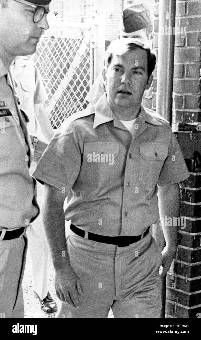 Convicted of the murder of 102 Vietnamese civilians  -the My Lai Massacre - former U.S. Army Lieutenant William Calley (center) is escorted from the Fort Benning, Georgia confinement facility to a federal appeals court in nearby Columbus, Ga. At a later date, Calley's original sentence of life in prison was turned into an order of house arrest, but after three years, President Richard Nixon reduced his sentence with a presidential pardon. Stock Photo