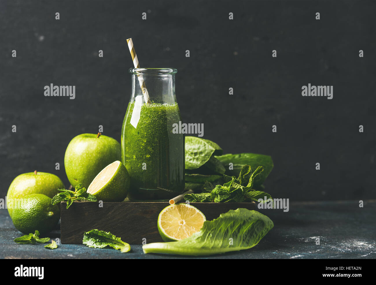 Smoothie with apple, romaine lettuce, lime, mint, dark blue background