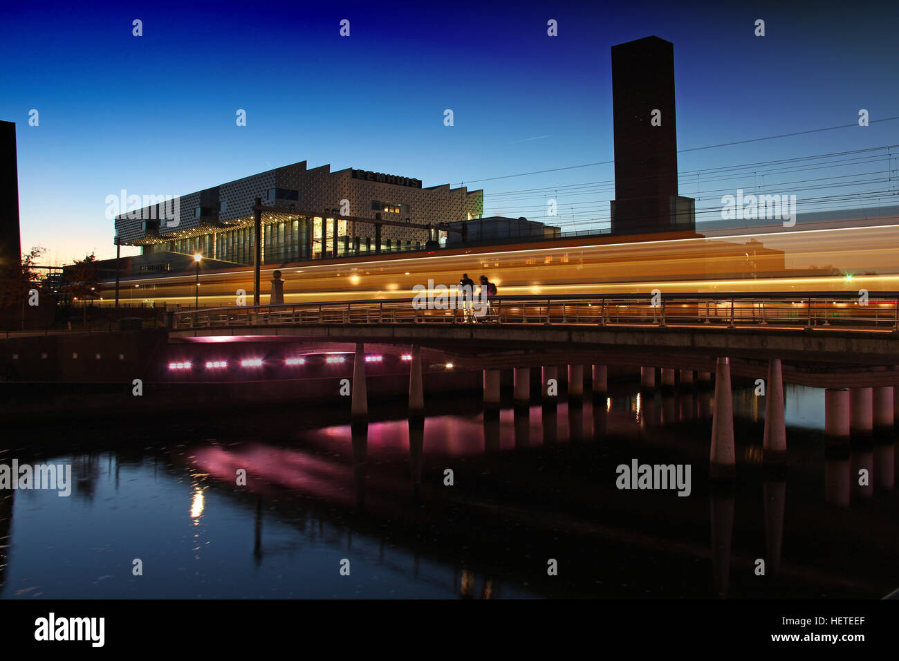 Sunset in Amersfoort with a train passing by on a bridge with the 'Eemhuis' in the background Stock Photo