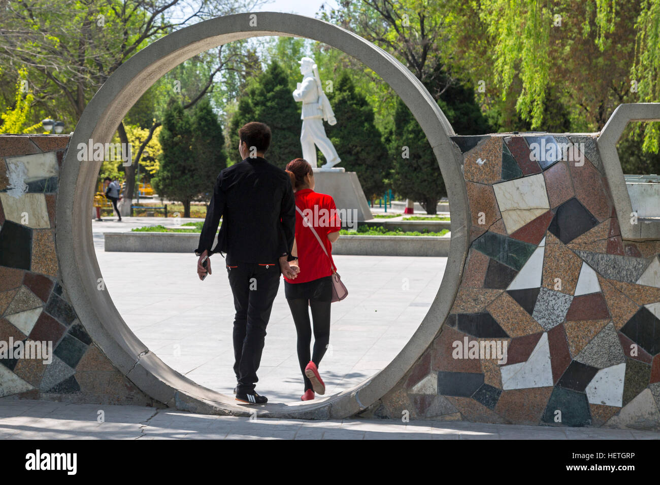 Statue, archway and couple in Zhongshan Park, Yinchuan, Ningxia, China Stock Photo