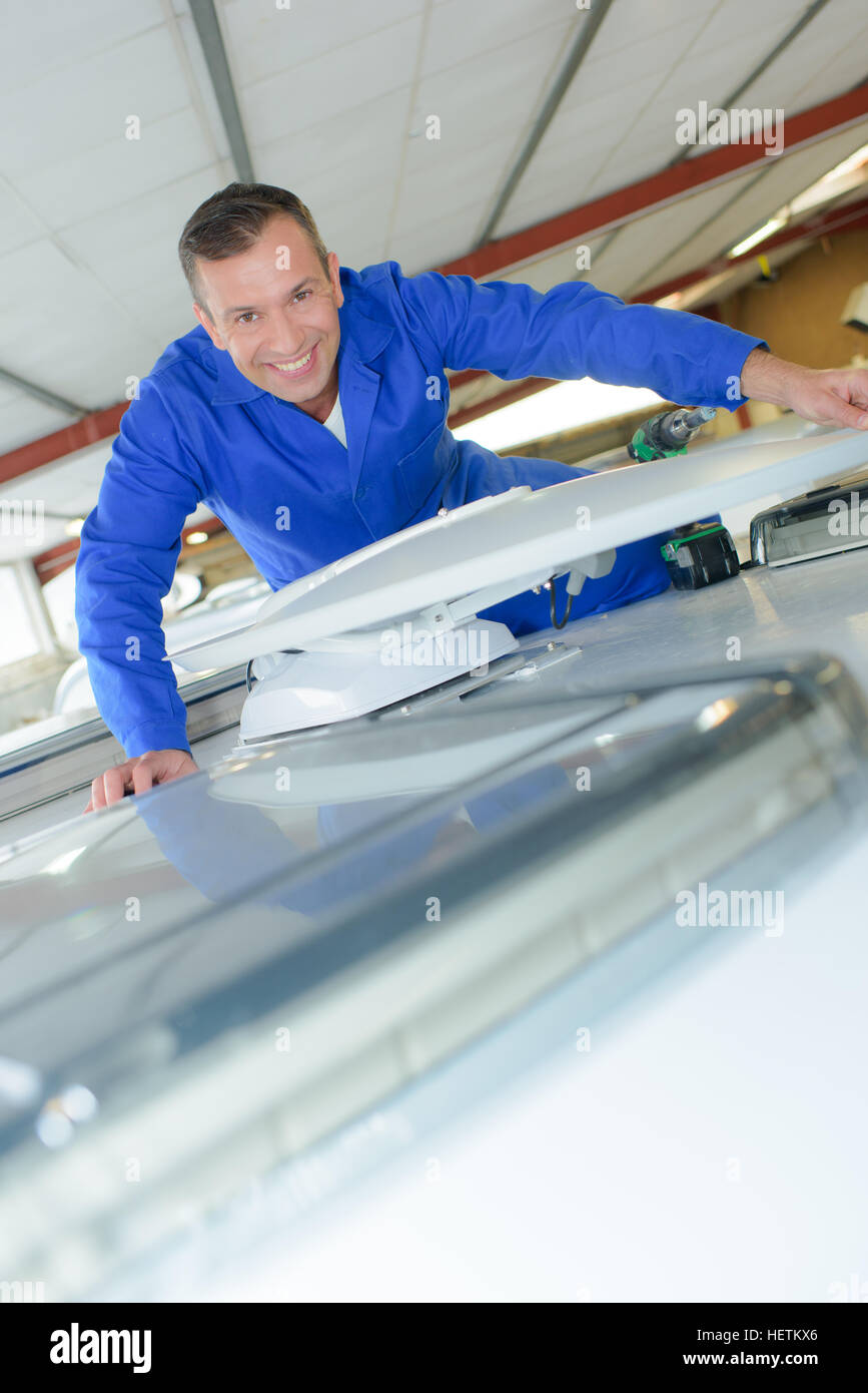 Portrait of mechanic on roof of camper van Stock Photo Alamy