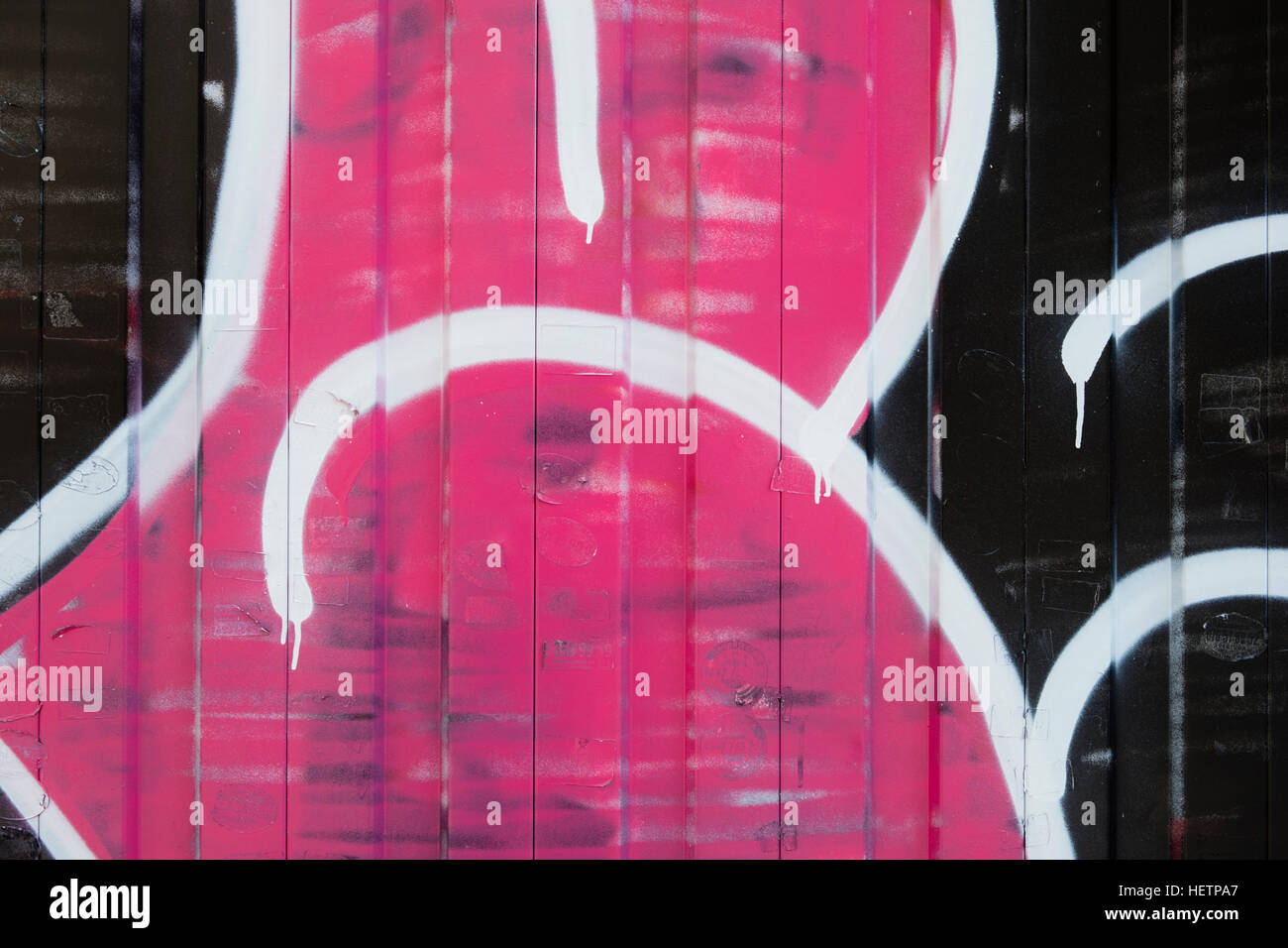 Detail of painted wall with so called 'graffiti', in pink, white and black. Stock Photo
