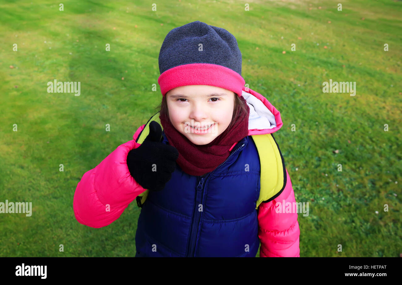 Little girl smiling on background of the green grass Stock Photo