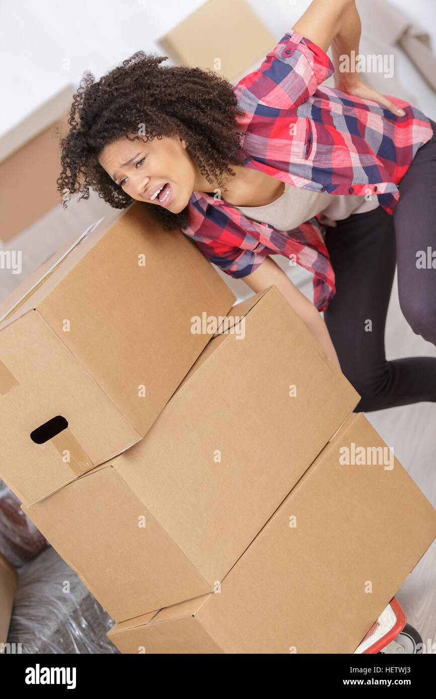 woman with backache while lifting box Stock Photo