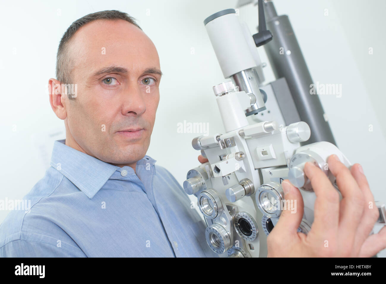Optician with eye testing equipment Stock Photo