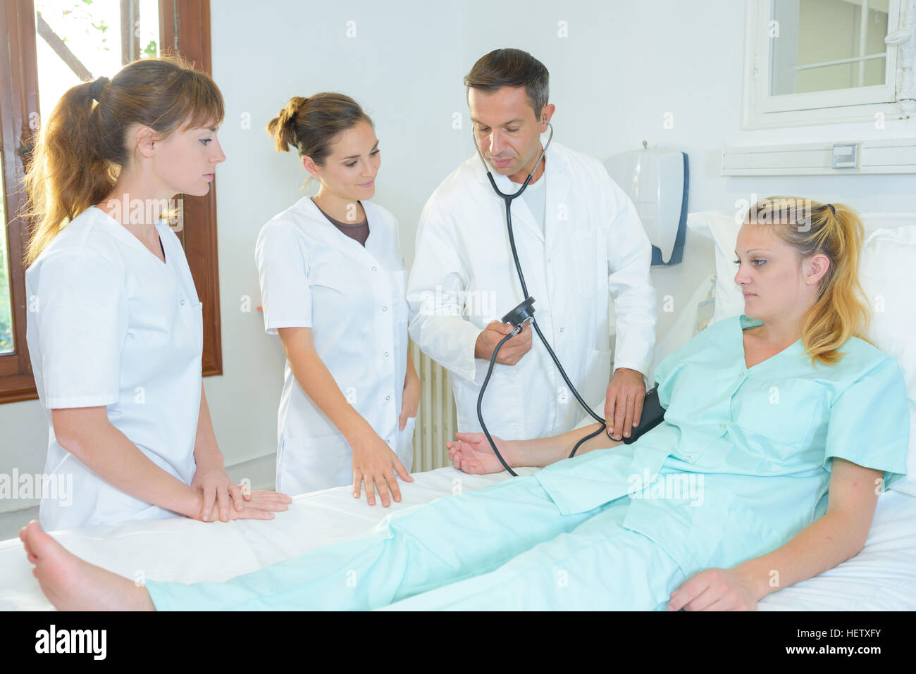 Medical students around patient's hospital bed Stock Photo