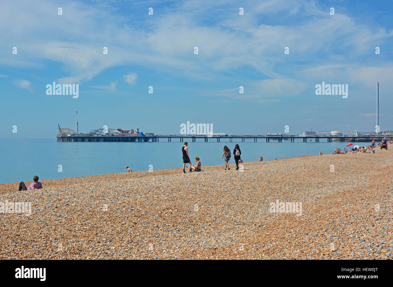 Seafront and shingle beach at Brighton in East Sussex, England. With pier and British Airways i360 observation tower. People on beach. Heat haze disto Stock Photo