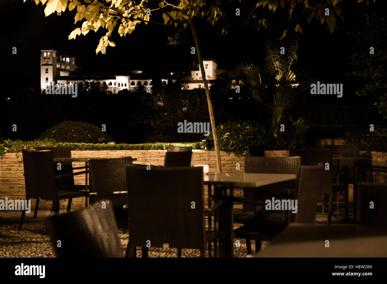 Ancient building seen from an empty terrace of a restaurant at night Stock Photo