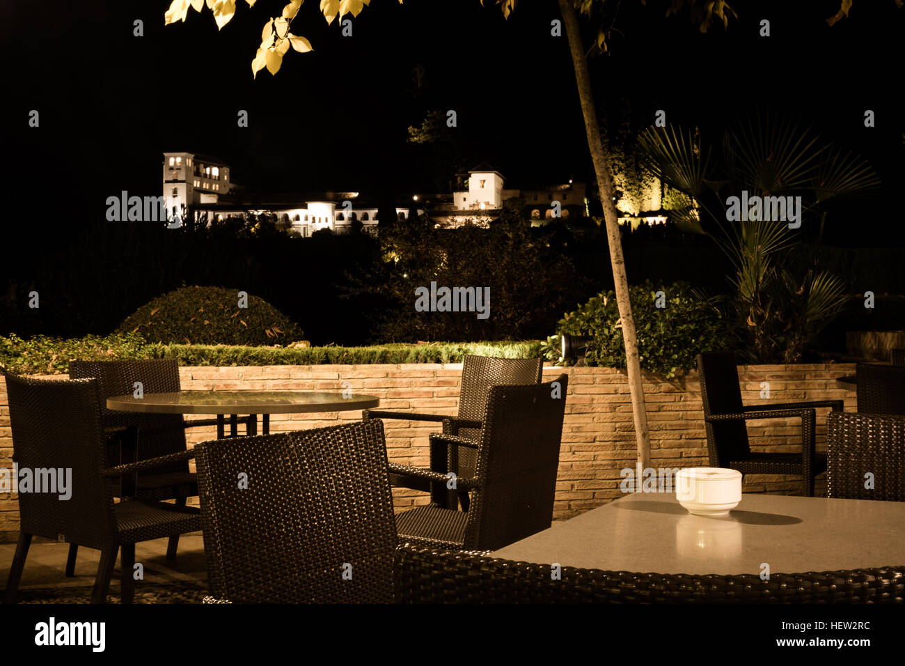 Ancient building seen from an empty terrace of a restaurant at night Stock Photo