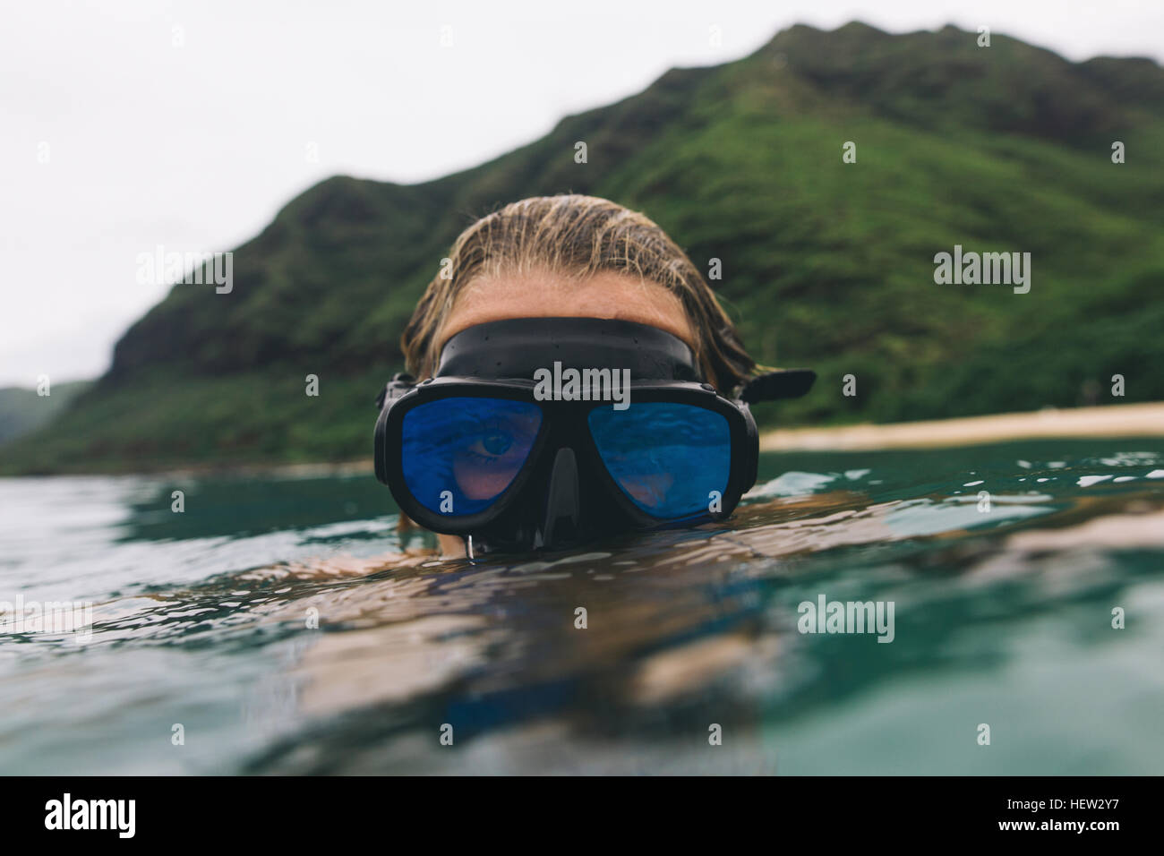 Swimmer wearing goggles near surface of sea Stock Photo