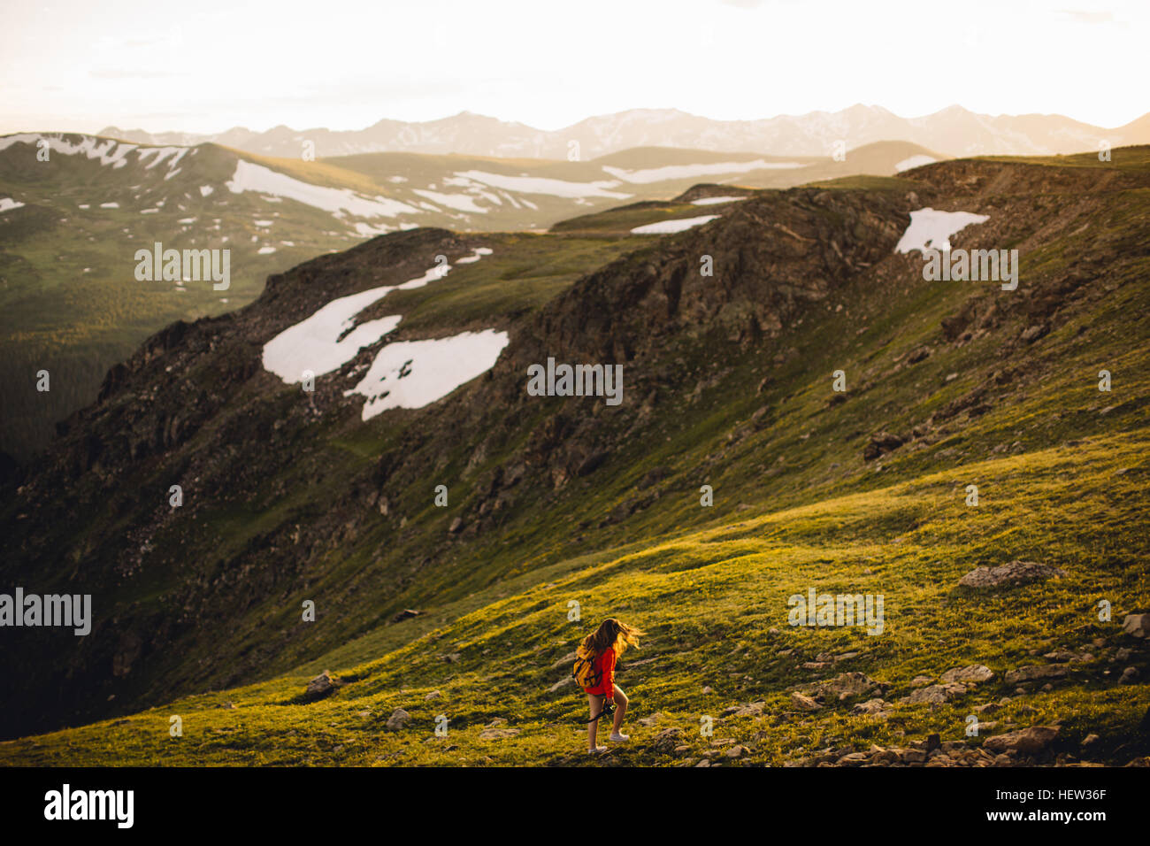 Woman hiking on snow capped mountains, Rocky Mountain National Park, Colorado, USA Stock Photo