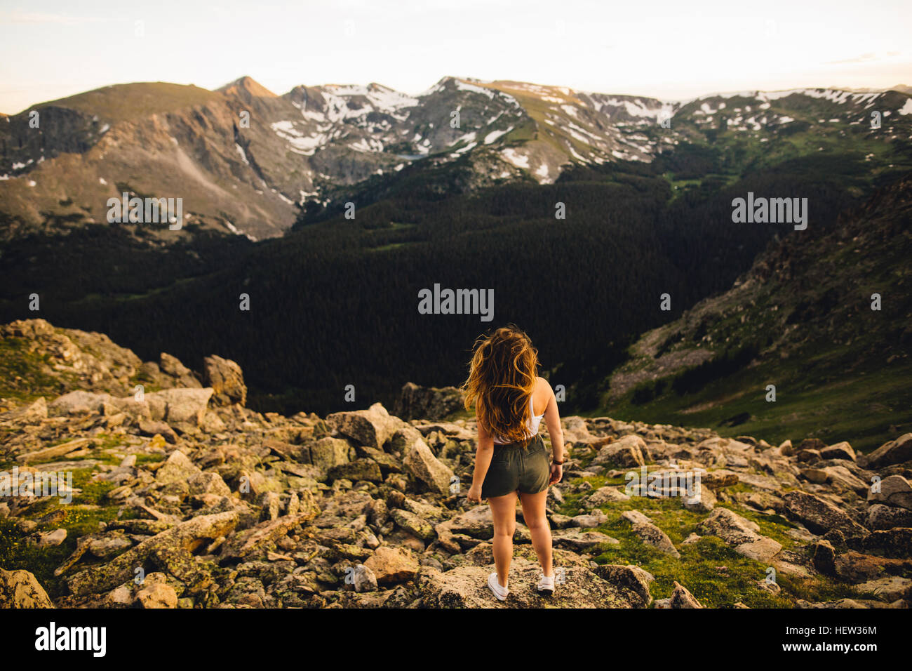Rear view of woman on rocky outcrop looking at view, Rocky Mountain National Park, Colorado, USA Stock Photo