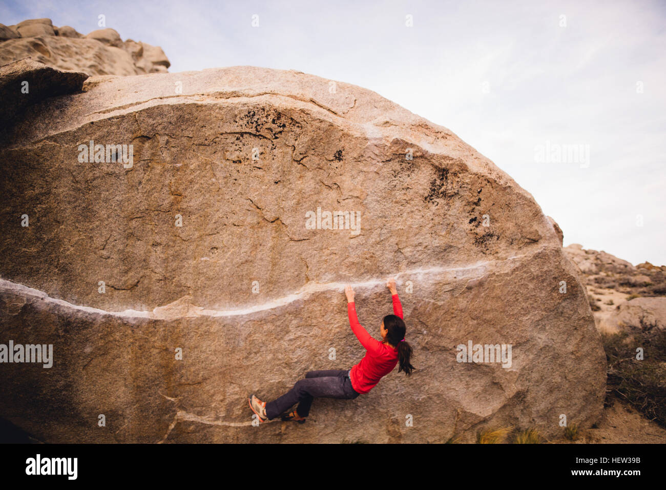 Woman rock climbing, Buttermilk Boulders, California, USA Stock