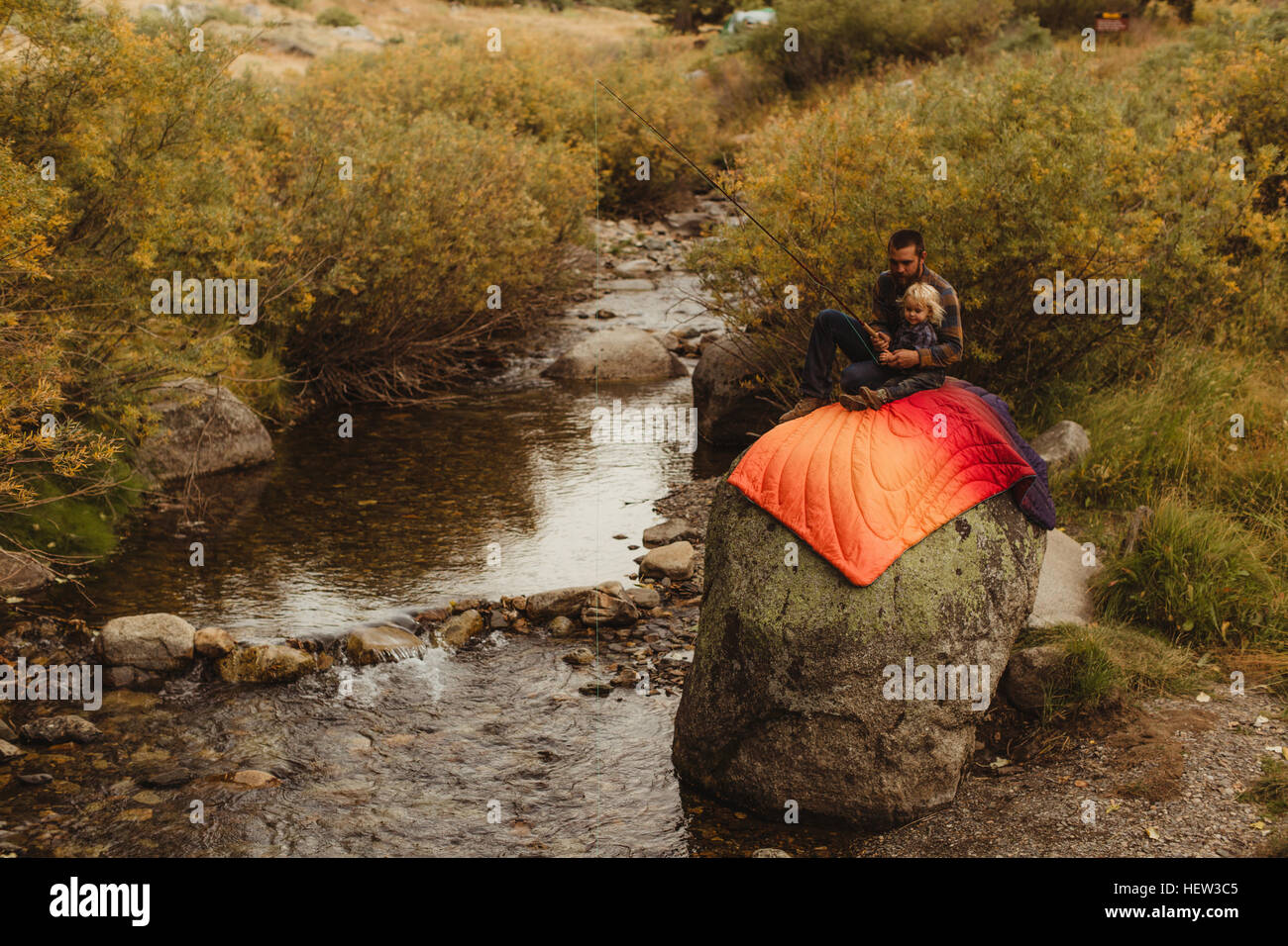 Father and son sitting on rock beside creek, father teaching son to fish, Mineral King, Sequoia National Park, California, USA Stock Photo
