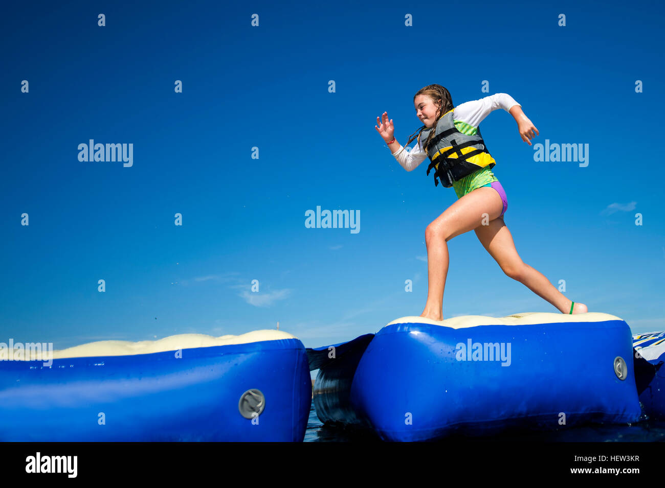 Girl running across inflatable platforms, Seaside Heights, New Jersey, USA Stock Photo