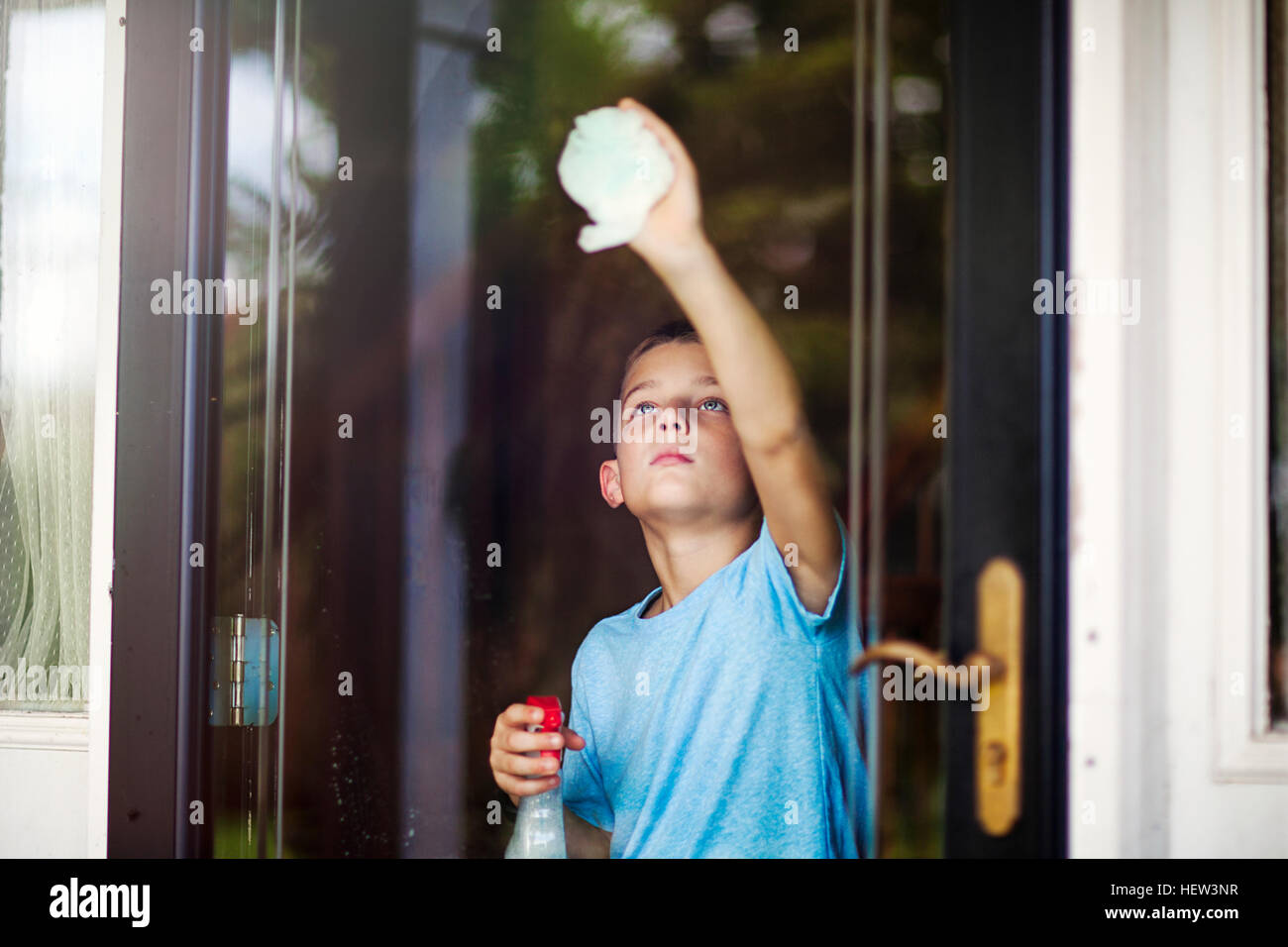 Boy reaching to clean glass door Stock Photo Alamy