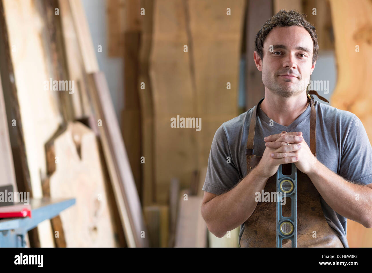 Carpenter at his workshop, holding woodwork tool Stock Photo