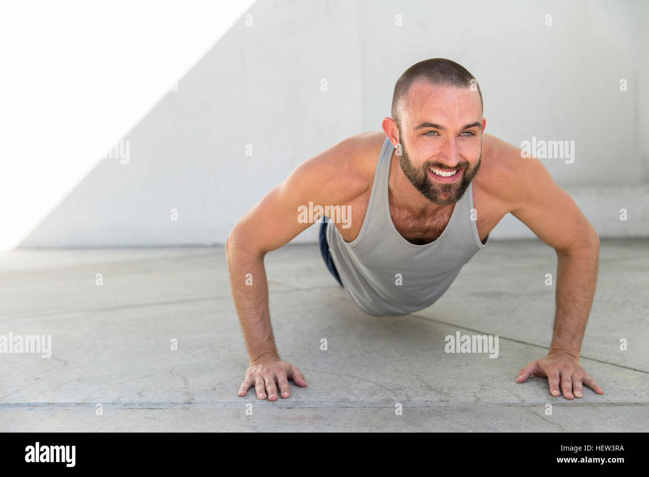 Mid adult man training doing push ups on patio Stock Photo