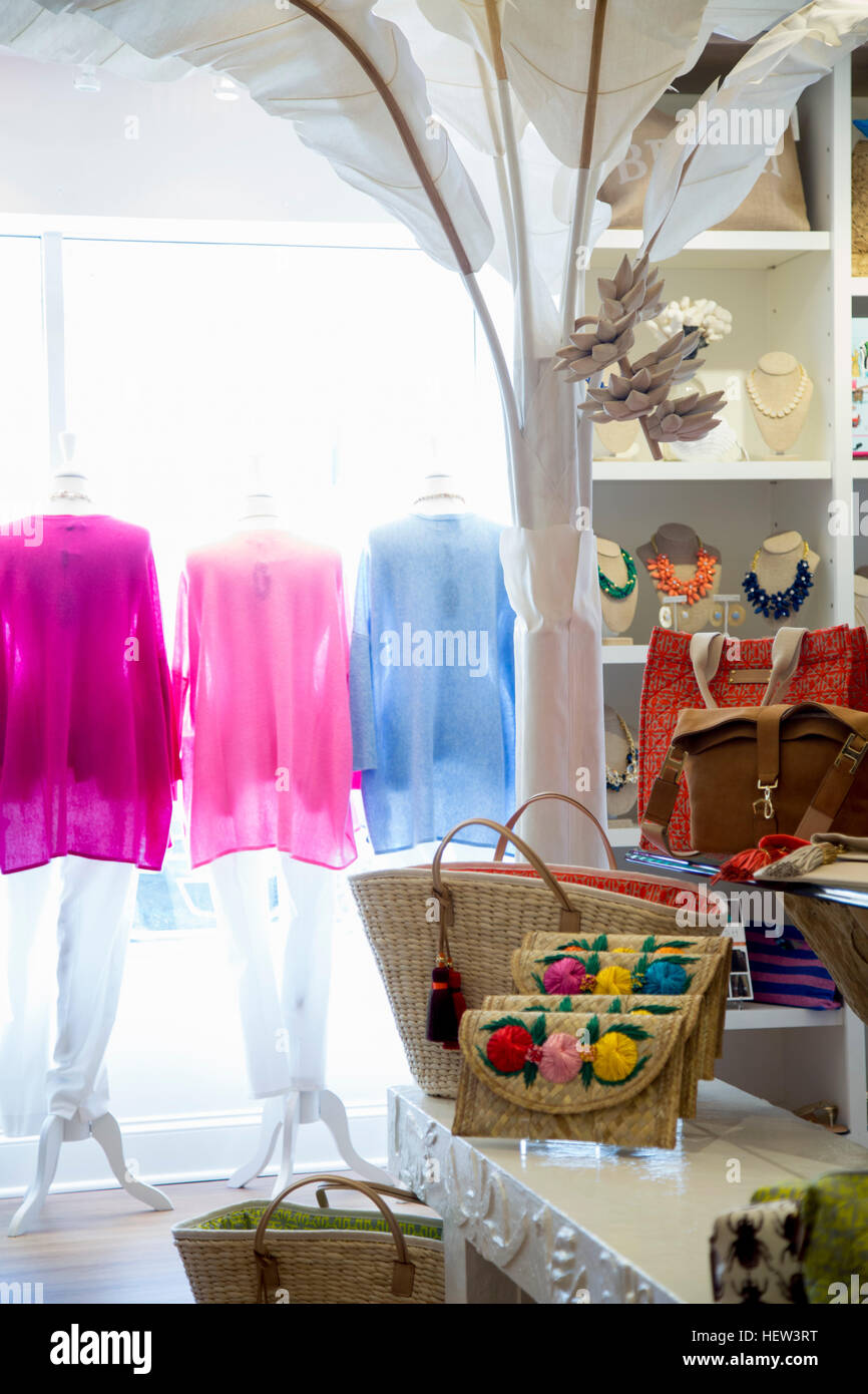 Row of colourful blouses on clothes rail in fashion boutique window Stock Photo