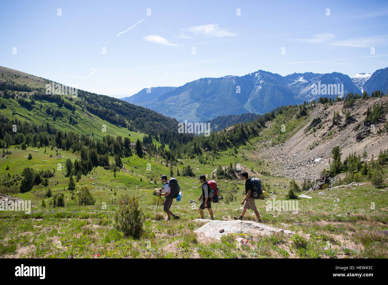 Hikers walking across valley, Enchantments, Alpine Lakes Wilderness, Washington, USA Stock Photo