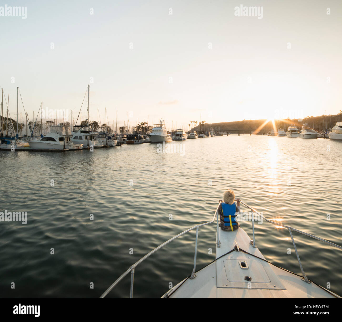 Rear view of boy on bow of boat, Dana Point, California, USA Stock Photo