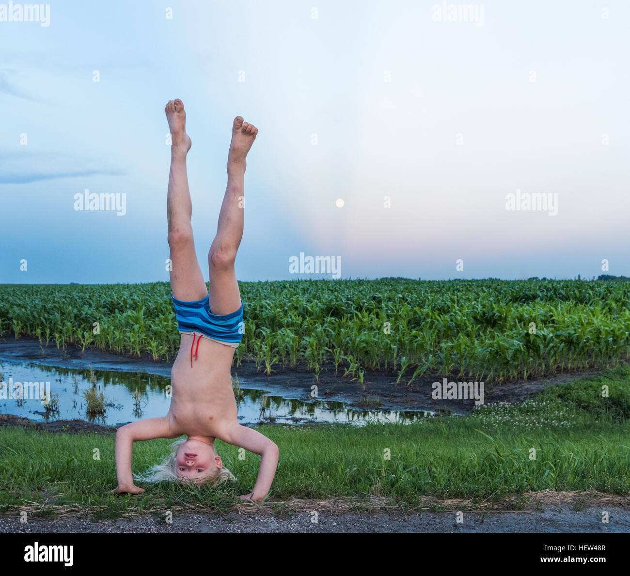 Boy wearing shorts doing handstand in rural area Stock Photo Alamy