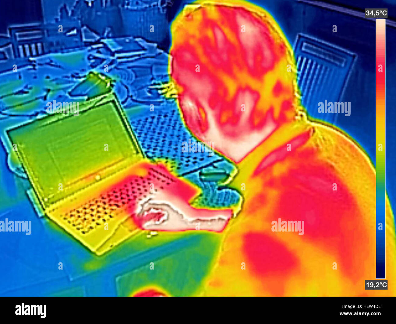 Infrared thermography image showing the heat emission when man used notebook Stock Photo
