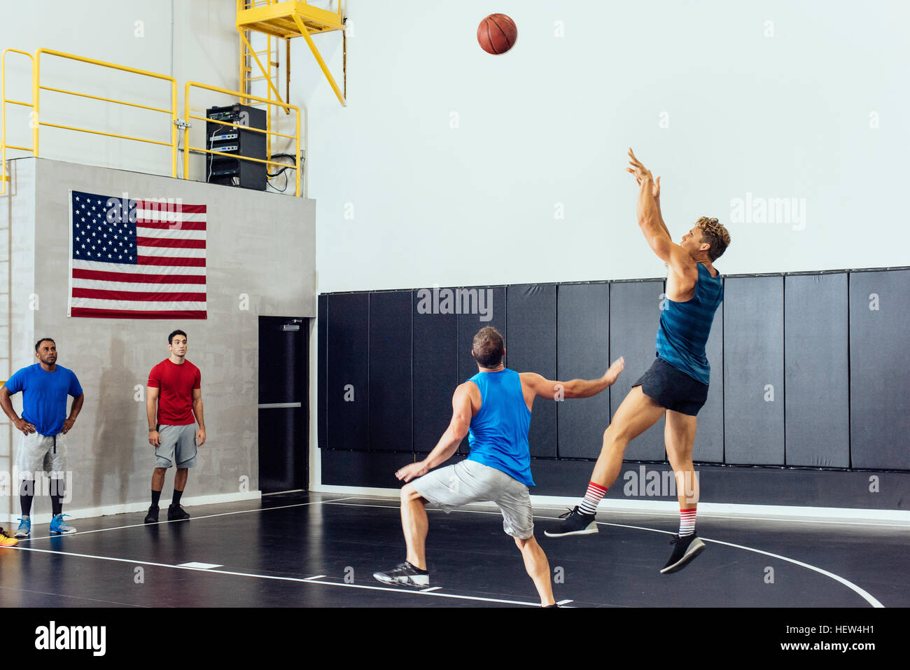 Male basketball player throwing ball toward hoop in basketball game Stock Photo Alamy