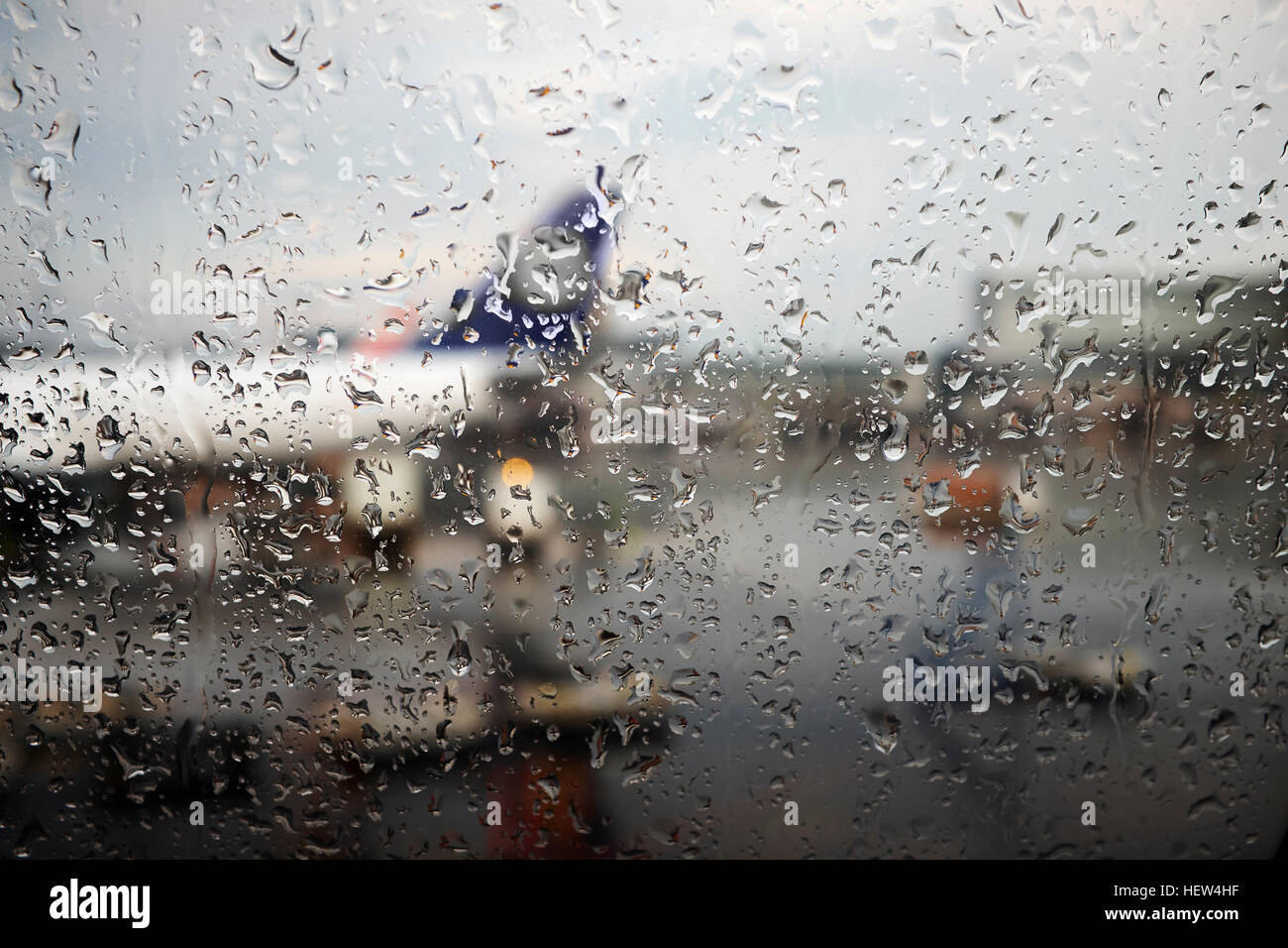 Window view of airplane parked in airport apron in rain Stock Photo