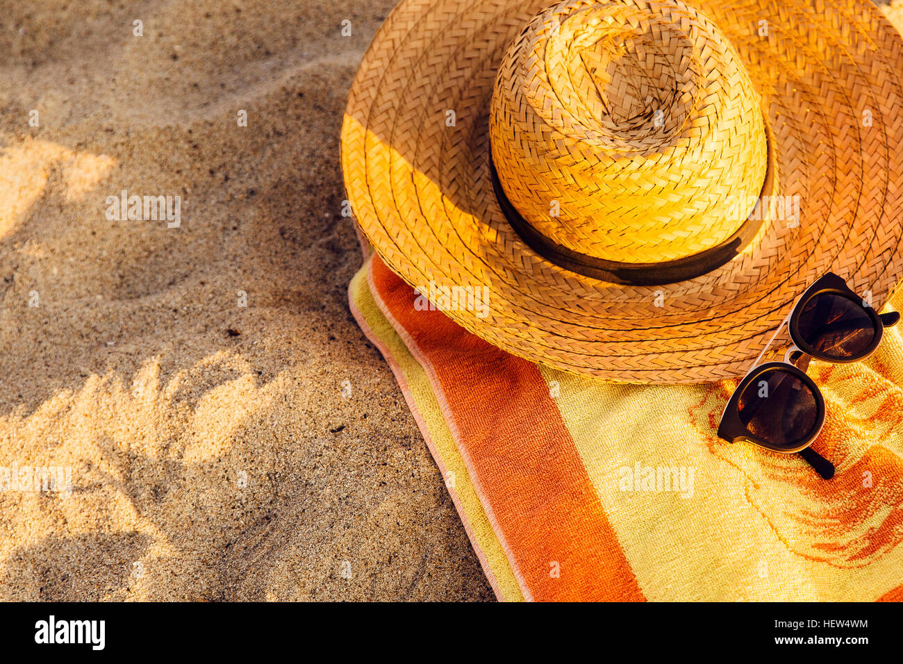 Summer beach bag with straw hat and sunglasses on sandy beach Stock Photo -  Alamy
