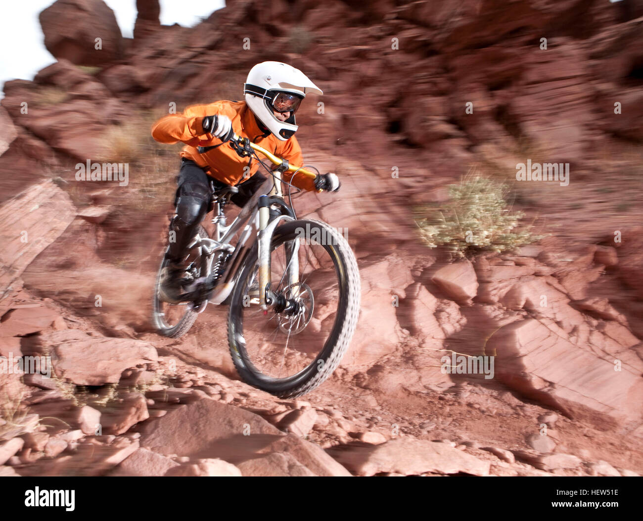 Young male downhill mountain biker speeding down muddy dirt track, Utah, USA Stock Photo