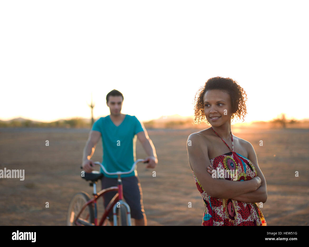 Young couple standing in desert at sunset Stock Photo