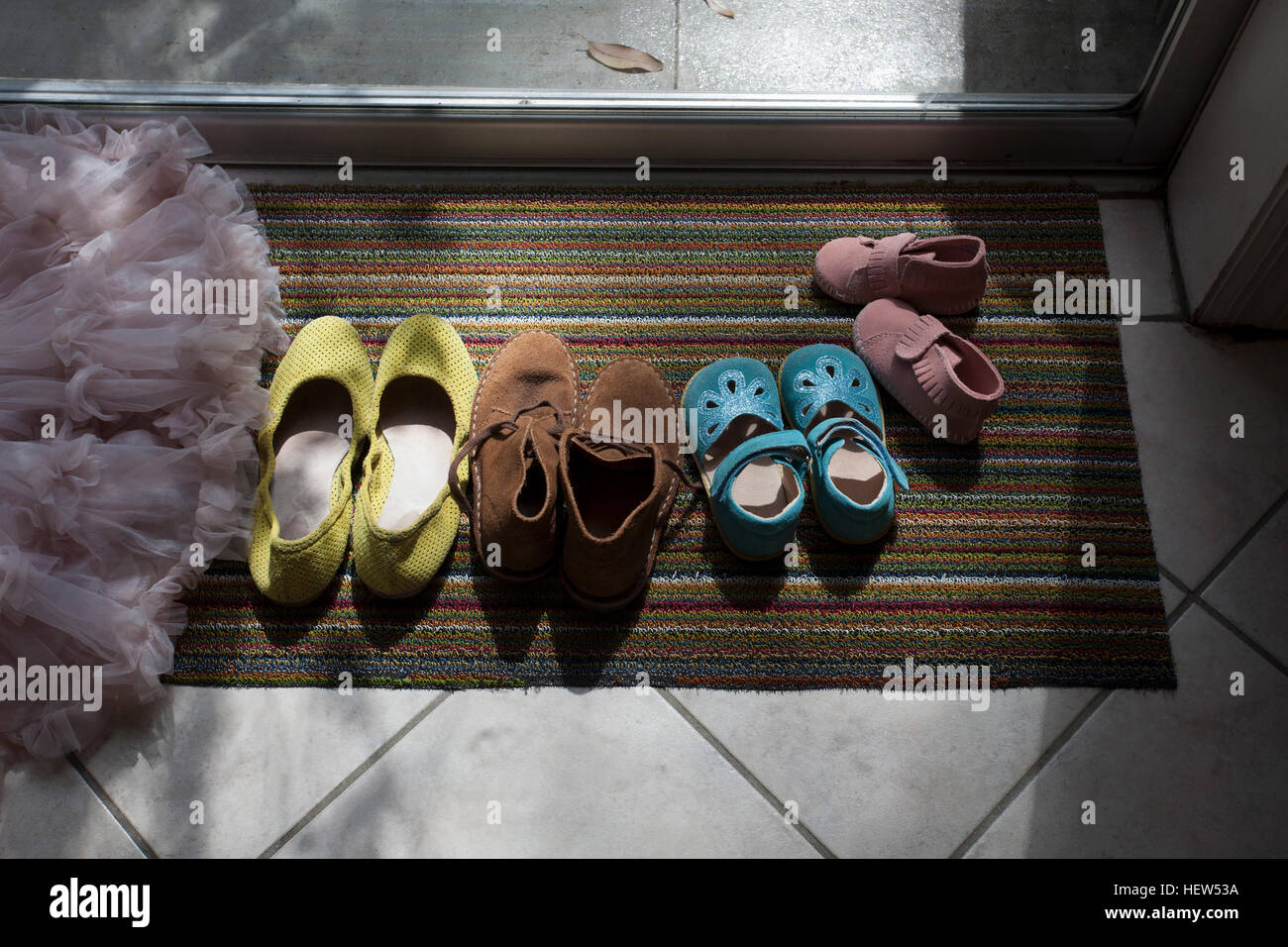 Different size shoes lined up on doormat Stock Photo