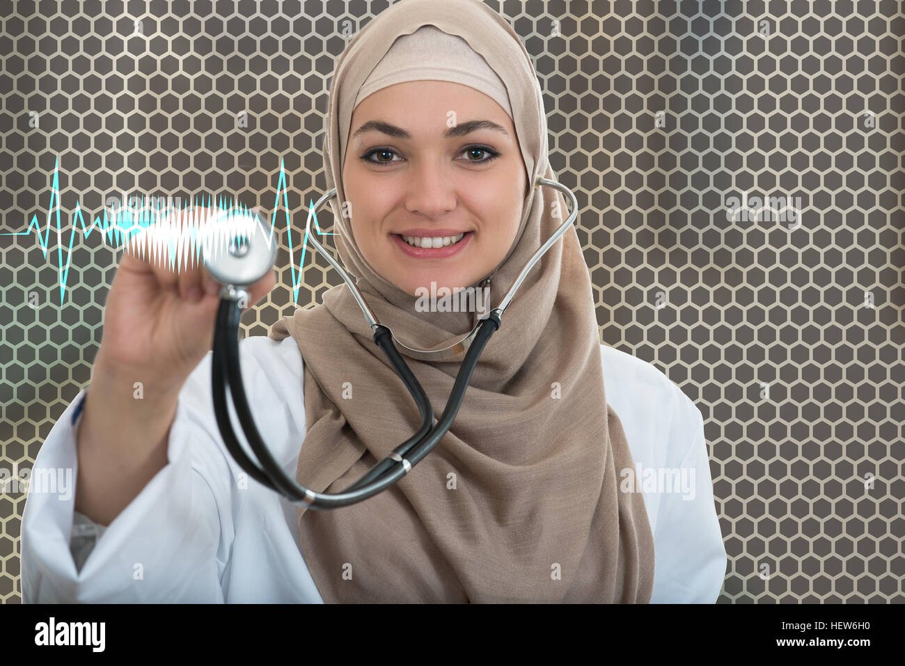 close up portrait of arab female doctor smiling while using stethoscope Stock Photo