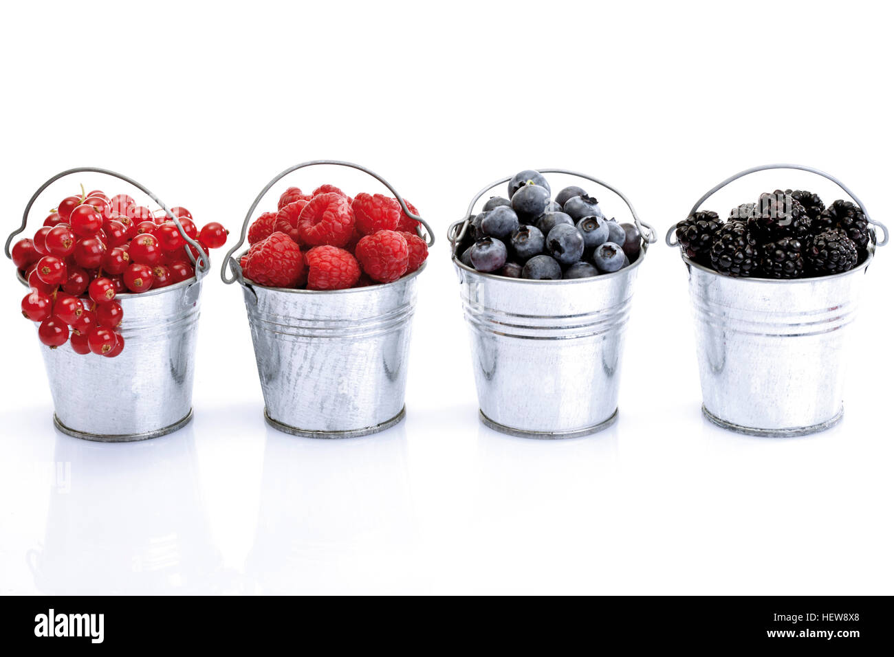 Four small galvanized buckets containing (left to right) red currants, raspberries, blueberries and blackberries Stock Photo