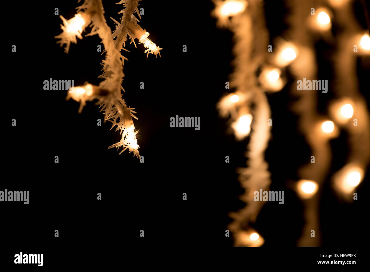 white christmas lights on roof against dark background with icing and