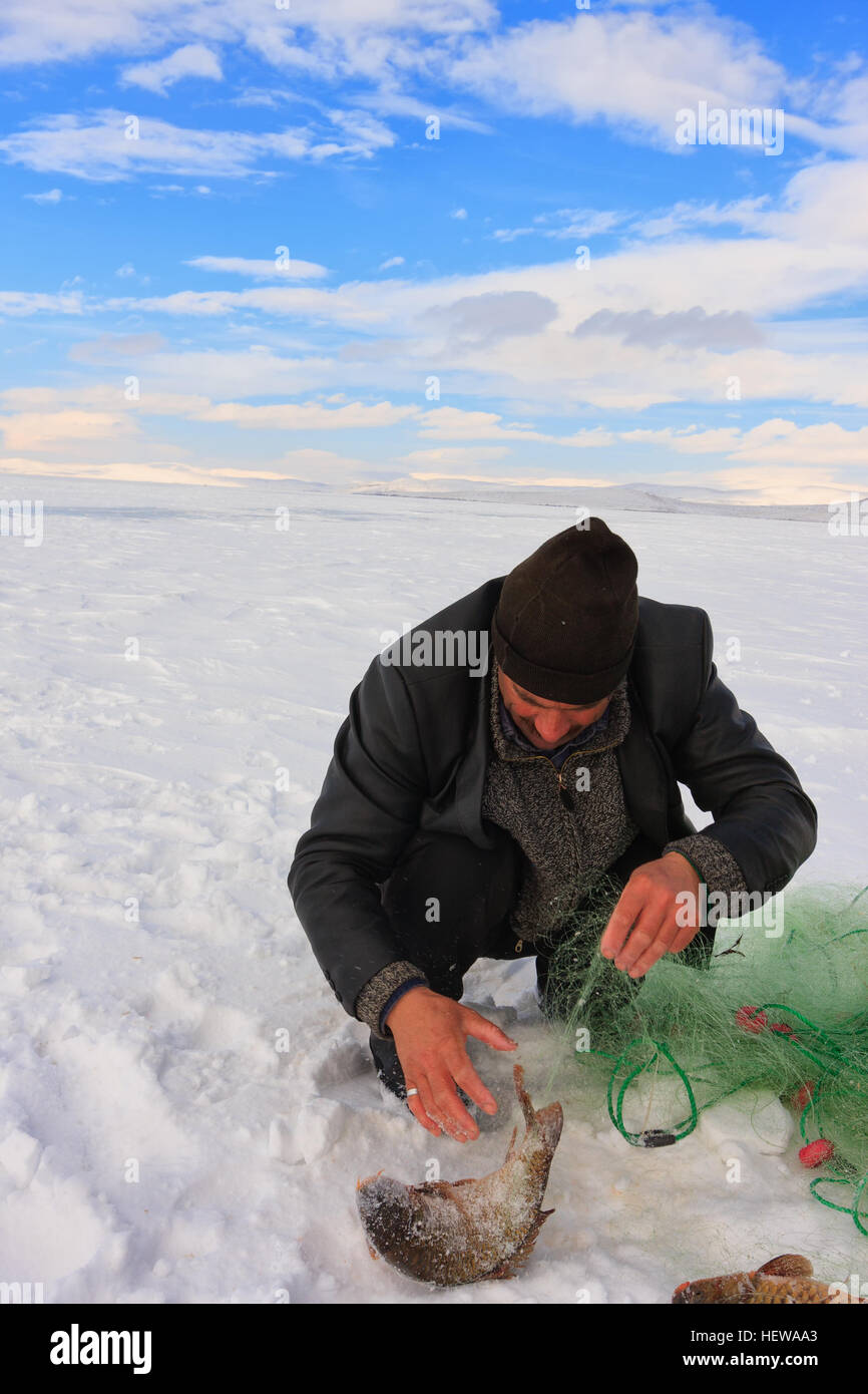 Fishermen catches fishes on Lake Cildir (Cıldır Golu) which is frozen every winter.The Lake is located on Eastern Anatolia,Kars Stock Photo