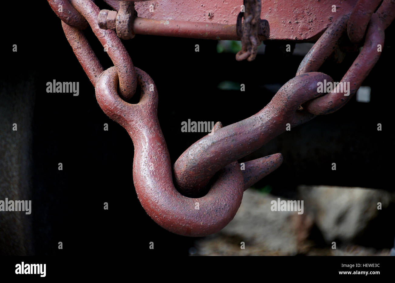 Coupling is done by a worker who must climb between the cars. First he winds the turnbuckle to the loose position, and then he can hang the chain on the hook. After hanging the chain on the towing hook the turnbuckle handle is stowed on the idle hook to prevent damage to itself, the vehicle, or the brake pipes. Only shunting is permitted with a dangling chain. Disconnected brake pipes must be stowed on dummy connectors, to allow proper operation of the brakes. (The picture shows two coupled cars, with a single brake pipe.)  The hooks and chain hold the carriages together, while the buffers kee Stock Photo