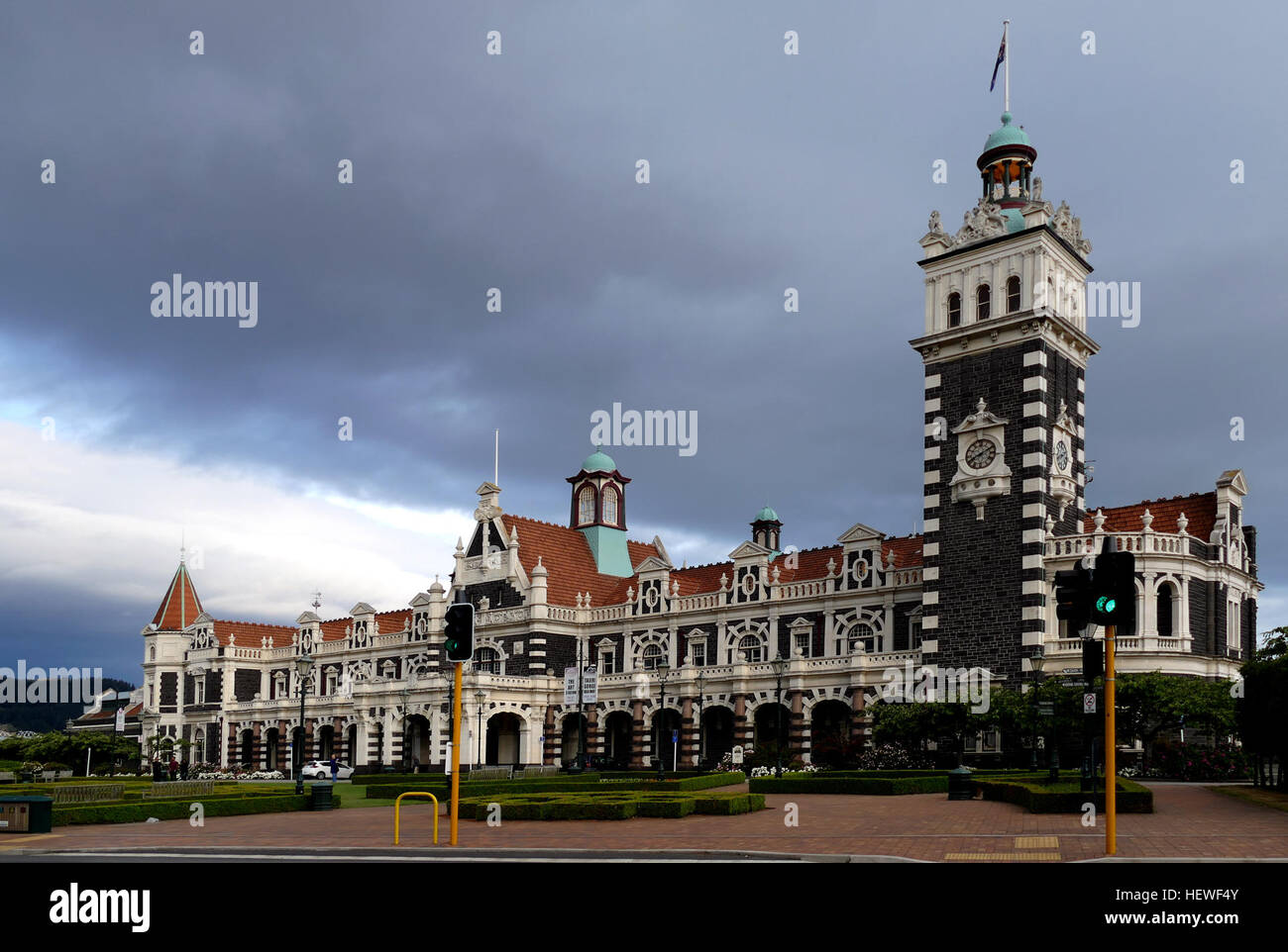 Marvel at the size, architecture and rich embellishments of Dunedin Railway Station - it's the grandest 'Gingerbread House' you'll ever see.  In the early 1900s Dunedin was the commercial centre of New Zealand. A magnificent railway station befitting this status was opened here in 1906.  Today the station remains, fully restored to its former glory. The ornate Flemish Renaissance-style architecture features white Oamaru limestone facings on black basalt rock. The sheer size, grandiose style and rich embellishments of the station earned architect George Troup the nickname of Gingerbread George. Stock Photo