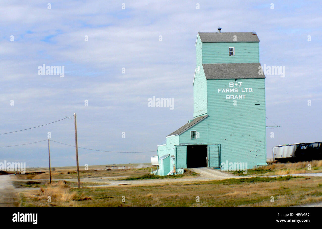 Brant is located 18 km west and 12 kilometres north of Vulcan. It is located on the CP main line which runs from Aldersyde to Kipp. This elevator was originally a Home Grain elevator, but changed owners to Searle, Federal and finally Alberta Wheat Pool, before being sold to B &amp; J Farms Stock Photo