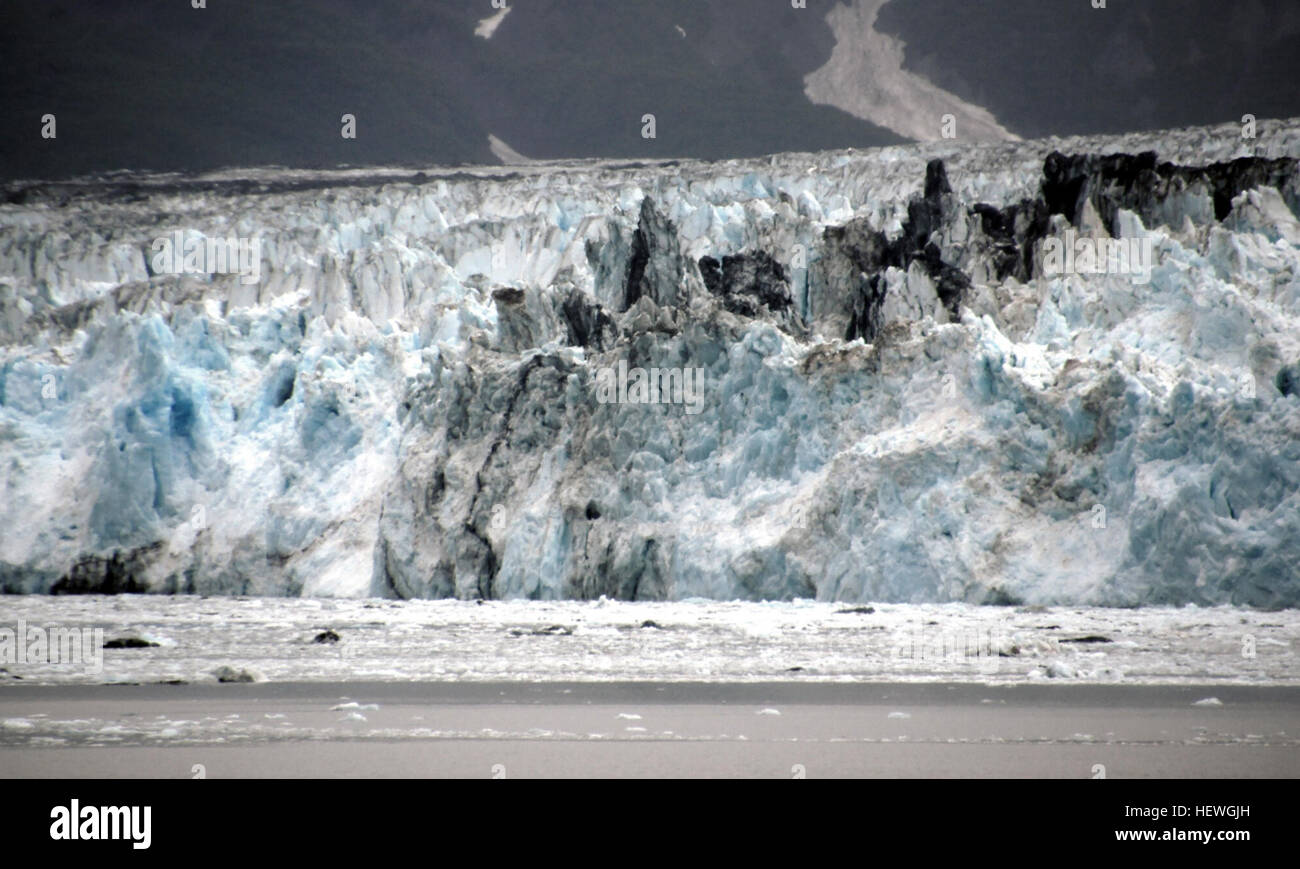 The longest source for Hubbard Glacier originates 122 kilometres (76 mi) from its snout and is located at about 61°00′N 140°09′W, approximately 8 kilometres (5 mi) west of Mount Walsh with an altitude around 11,000 feet (3,400 m). A shorter tributary glacier begins at the easternmost summit on the Mount Logan ridge at about 18,300 feet (5,600 m) at about 60°35′0″N 140°22′40″W. Before it reaches the sea, Hubbard is joined by the Valerie Glacier to the west, which, through forward surges of its own ice, has contributed to the advance of the ice flow that experts believe will eventually dam the R Stock Photo