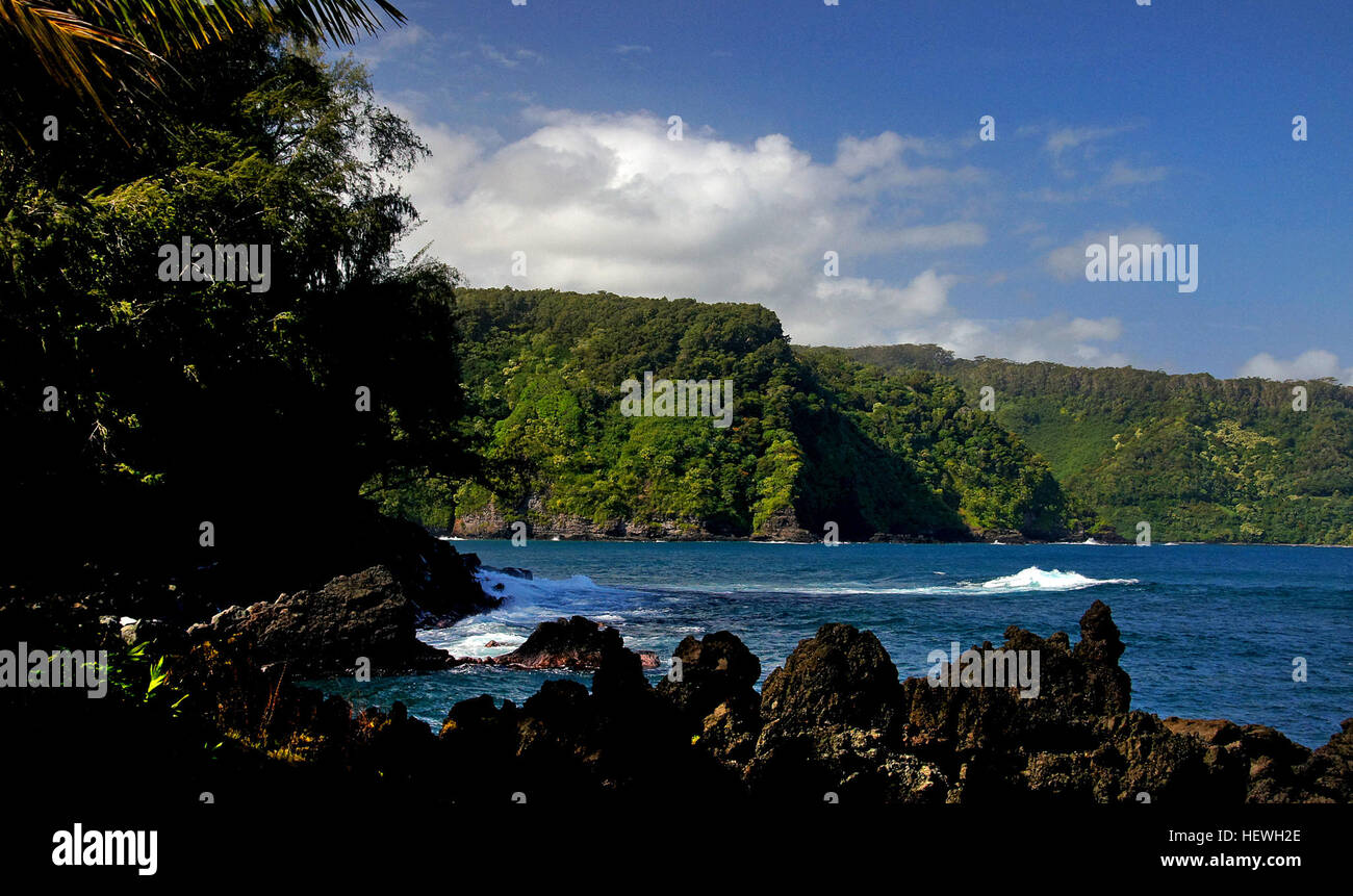 The Ke'anae Peninsula in Maui was formed by a massive lava flow from Haleakala Crater. Today, it is home to small local farms, taro fields, and offers dramatic views of the North Shore's powerful waves crashing against black lava rocks, making it a stunning photography destination. Stock Photo