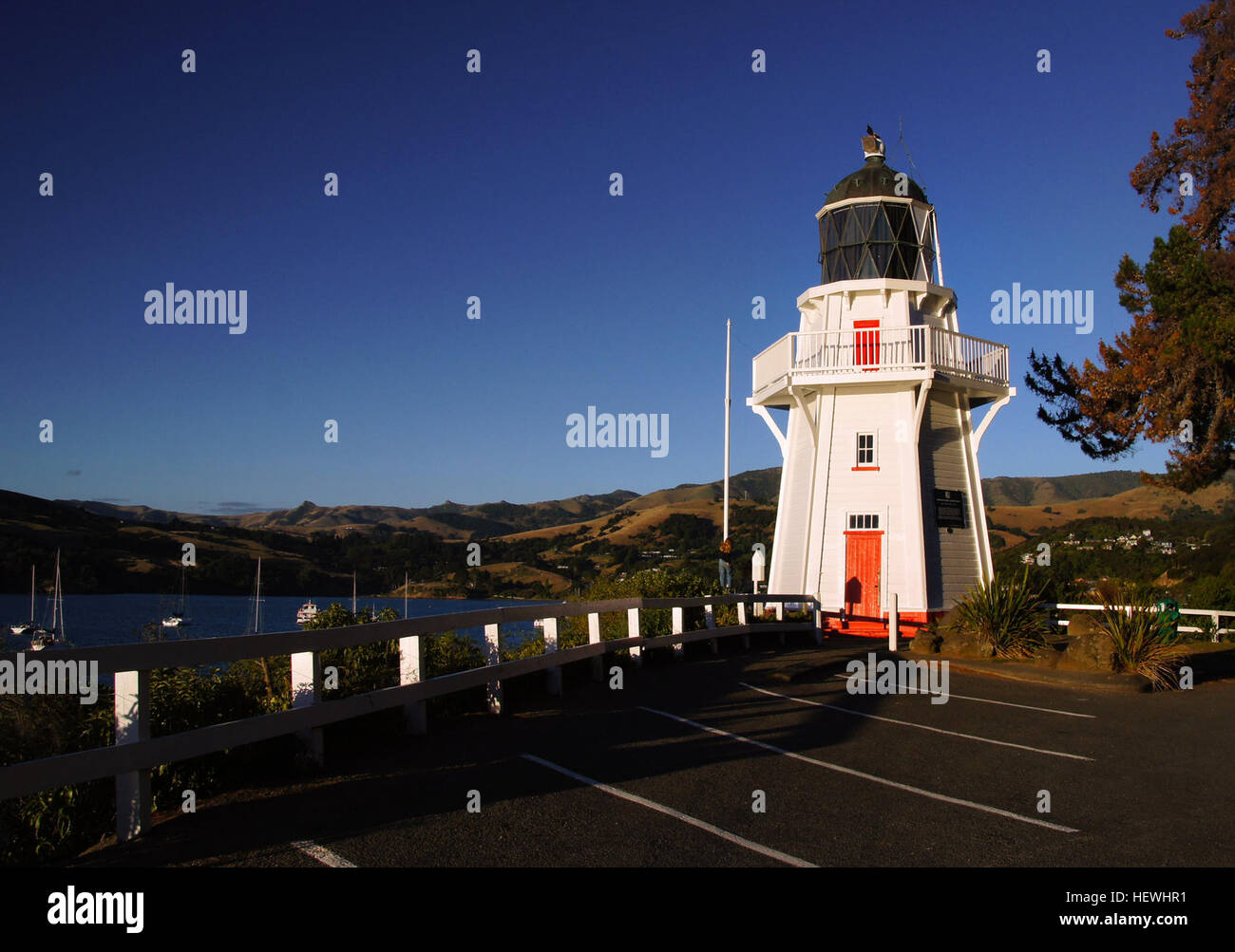 The Akaroa Lighthouse is one of the few remaining examples of early wooden lighthouses in New Zealand. The original Akaroa lighthouse started operation on Akaroa Heads in 1880 guided ships to and from the harbour for over one hundred years before it was moved to Akaroa township, after being replaced in 1977 by an automated light. The lighthouse was reassembled and restored by the Akaroa Lighthouse Prevention Society and was completed on 4 October, 1980. The foundations are all that remain of the lighthouse keeper’s family homes, but the original stonework of the supply road down to Haylocks Stock Photo