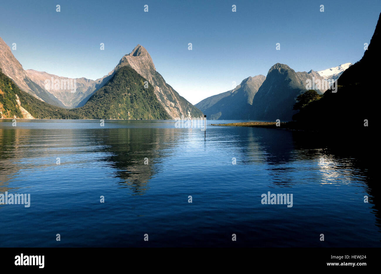 Milford Sound is a fiord in the south west of New Zealand's South Island, within Fiordland National Park, Piopiotahi Marine Reserve, and the Te Wahipounamu World Heritage site. Stock Photo